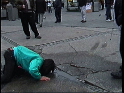 The artist is drinking water on the street in the former east Berlin.