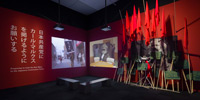 A large prit of Karl Marx's portlait and several red flag and two large scale video projection in the dark room.